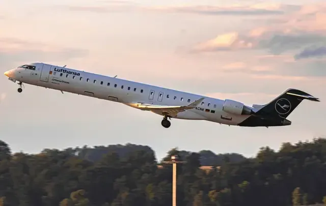 Lufthansa aircraft taking off at sunset