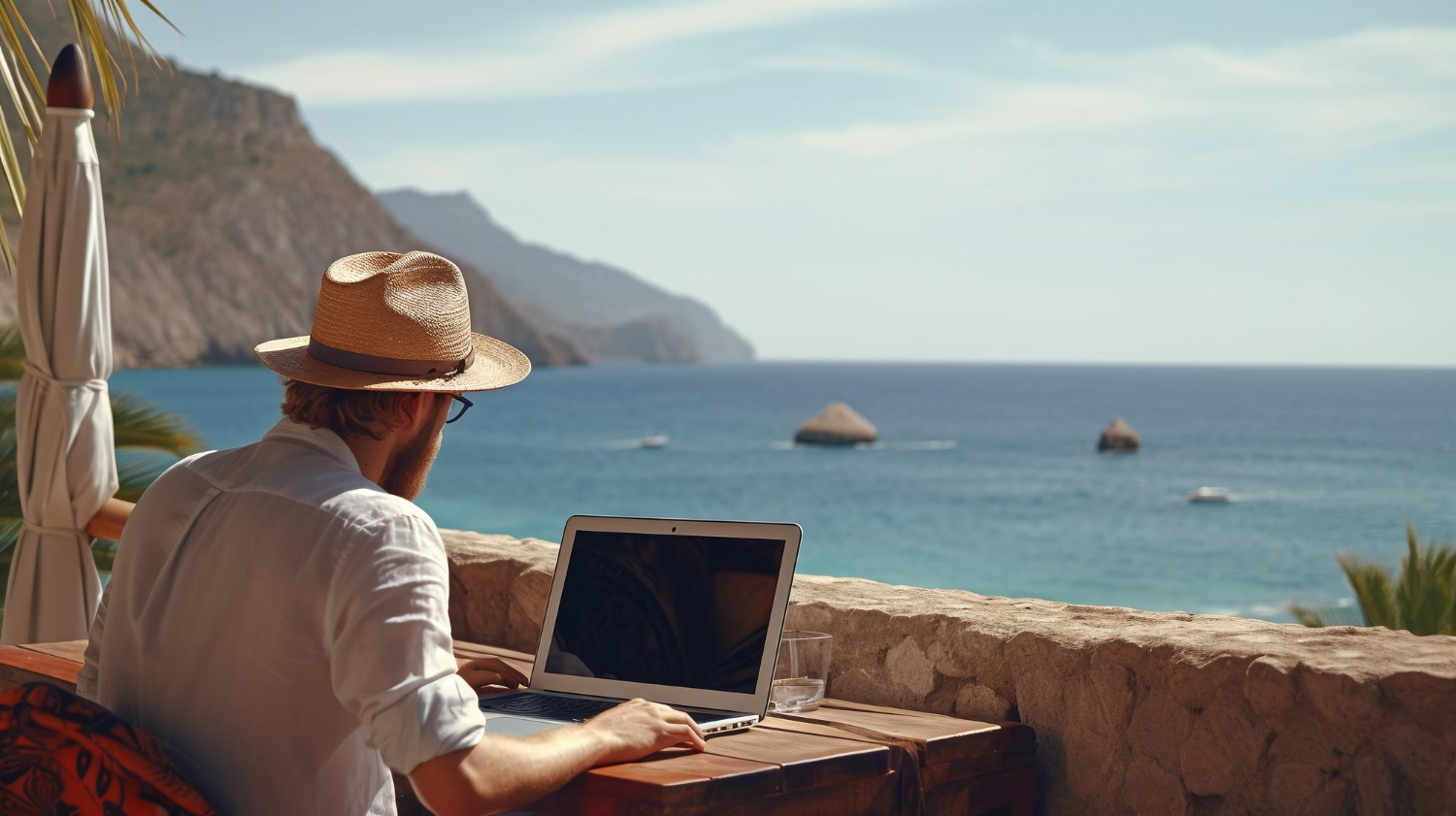 man working on laptop by the sea