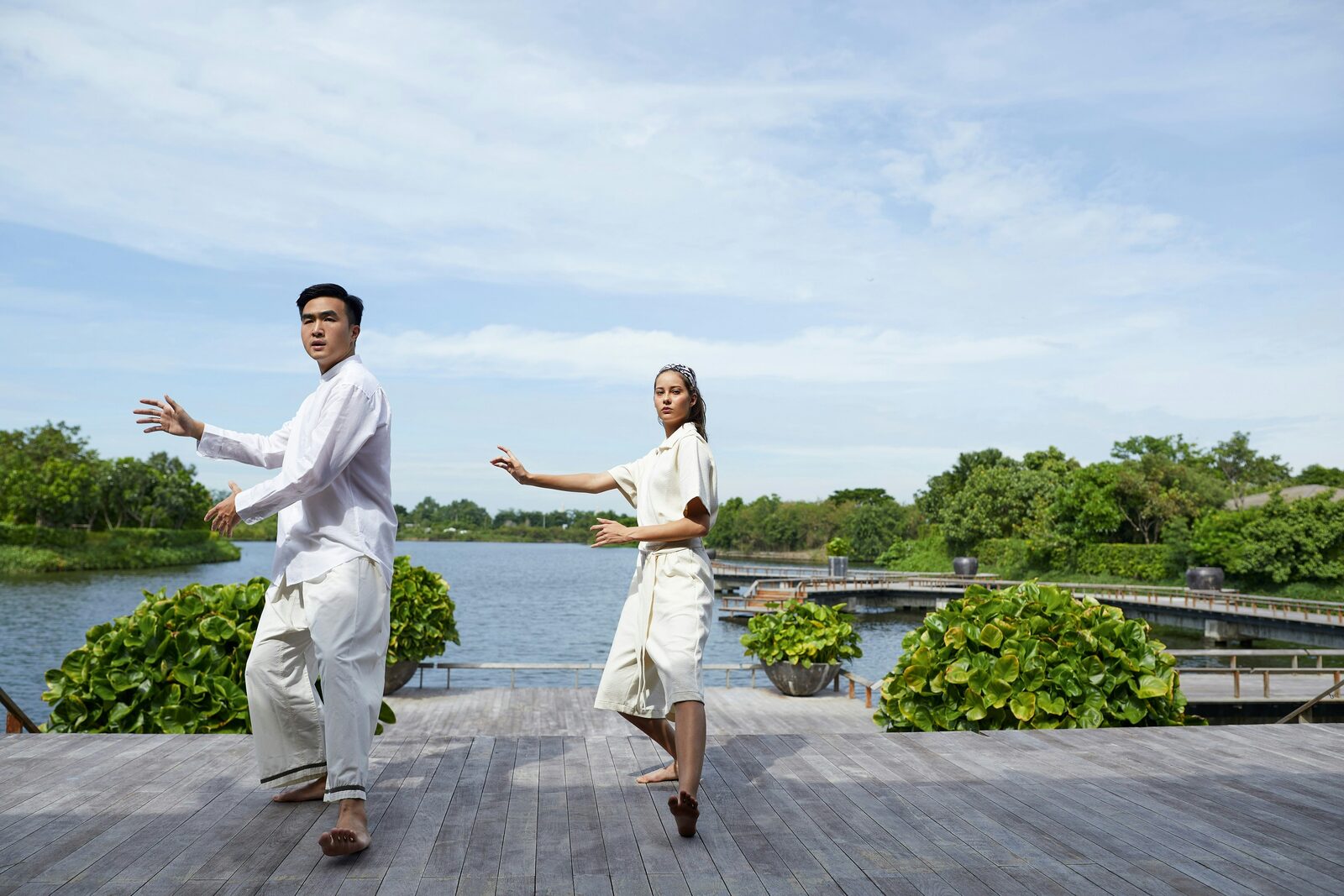 Two people walking a shallow waterway between trees