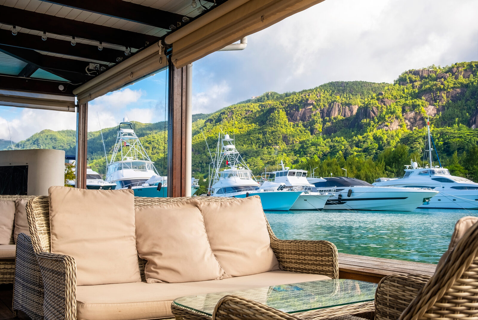 A shaded deck looking out over a bay of moored boats